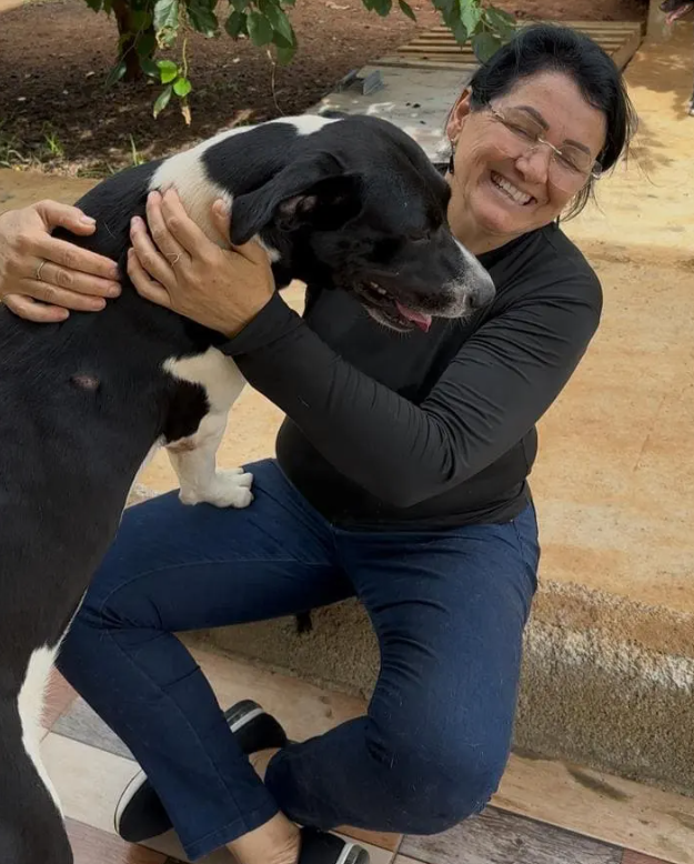 Tia Cleide abraçando um dos cães do abrigo